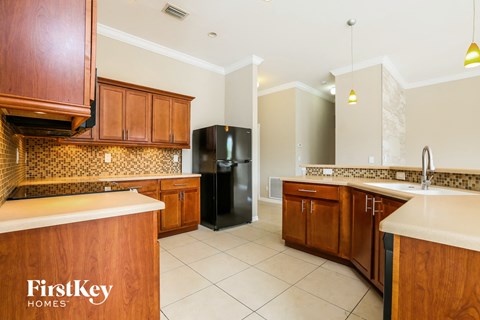 a kitchen with wooden cabinets and a black refrigerator
