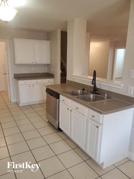 A kitchen with white cabinets and a stainless steel sink.