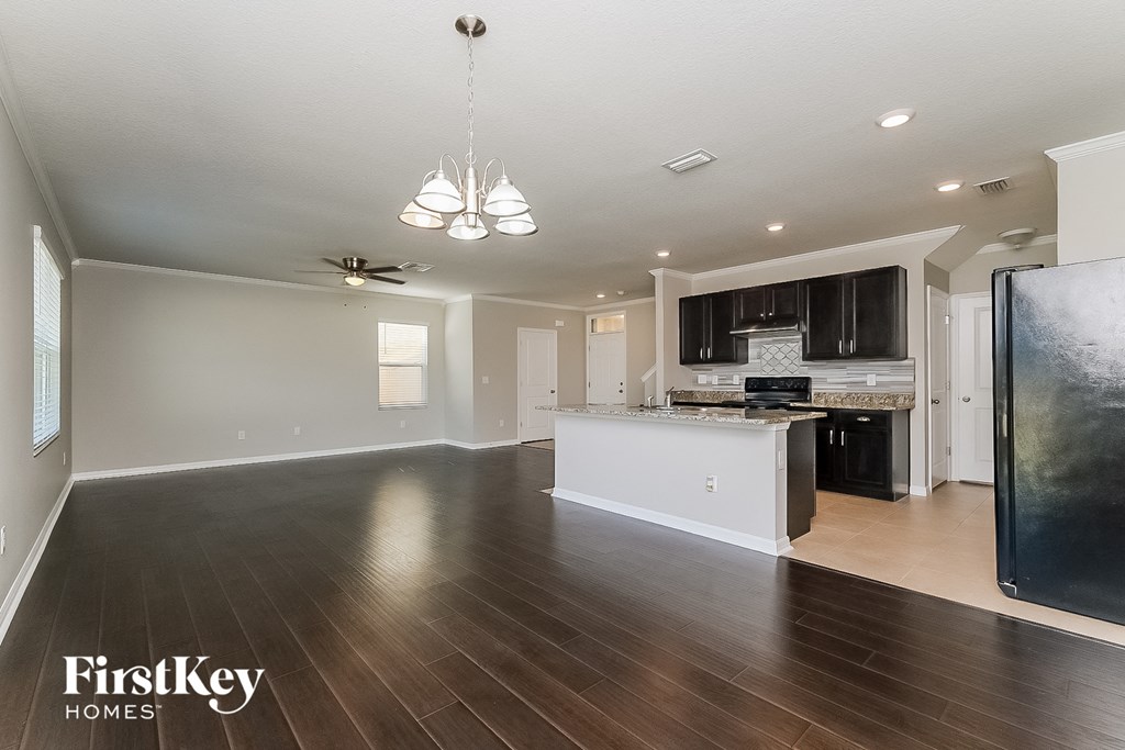 an open kitchen and living room with hardwood flooring and a kitchen island