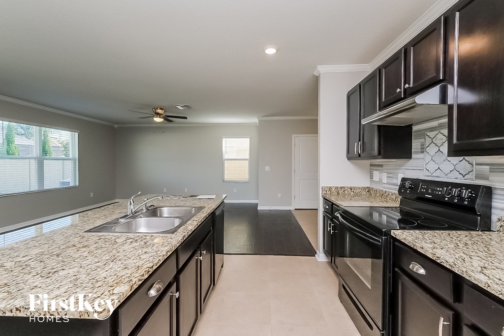 a modern kitchen with granite counter tops and black appliances