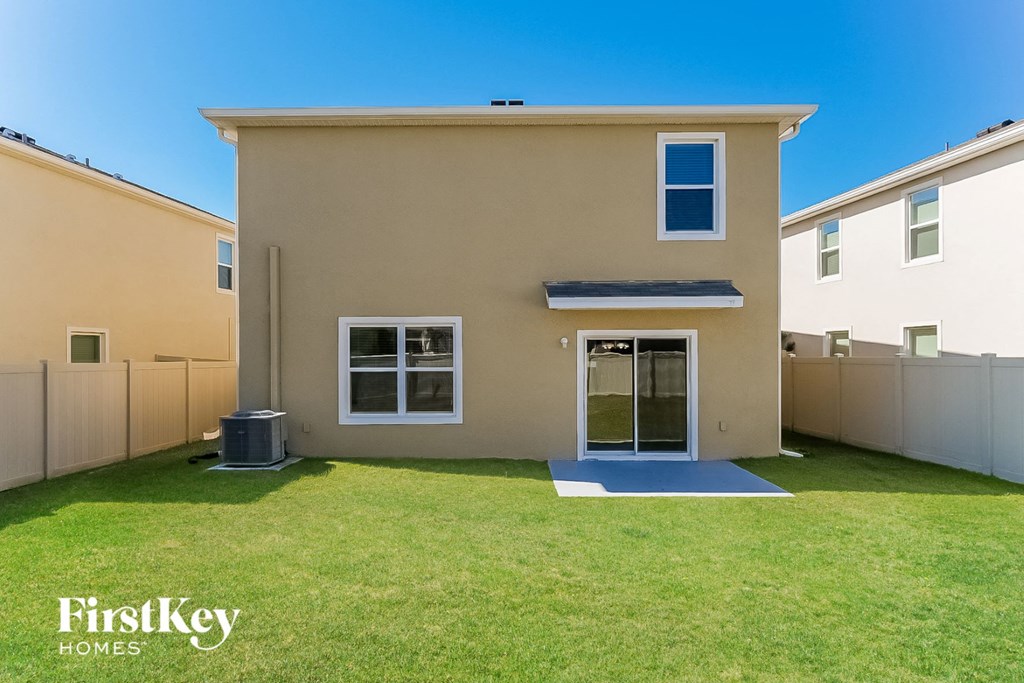 a large house with a grass yard and a backdoor