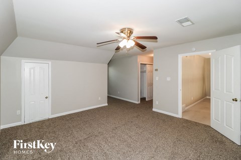 a bedroom with carpet and a ceiling fan