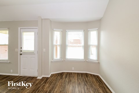 the living room of a home with wood floors and a white door