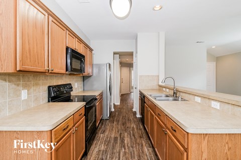 a kitchen with wooden cabinets and a black stove and a sink