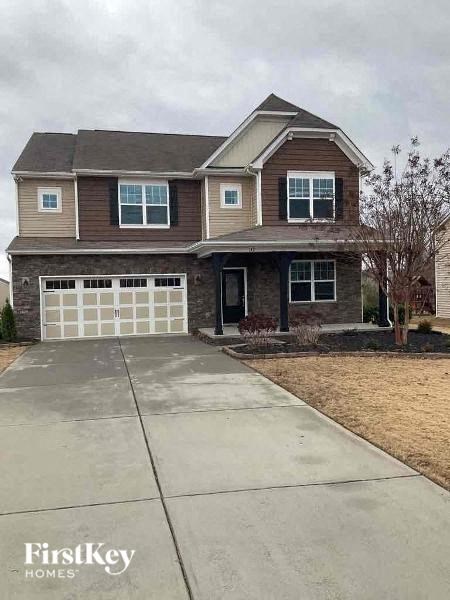 a two story house with a concrete driveway