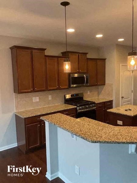 a kitchen with granite counter tops and wooden cabinets