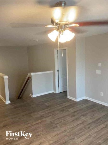 an empty living room with a ceiling fan