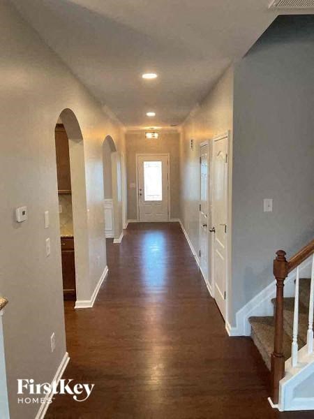 a hallway with a wooden floor and a white door