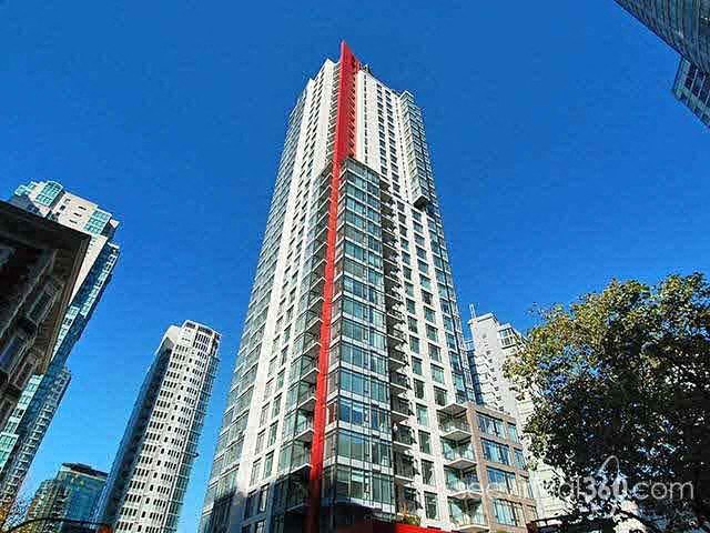 A tall building with a red stripe on the side stands out against the sky.