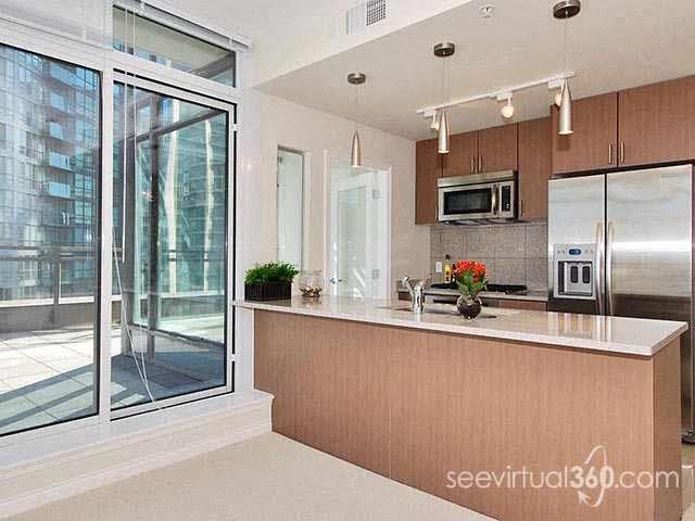 A kitchen with a refrigerator, microwave, and oven.