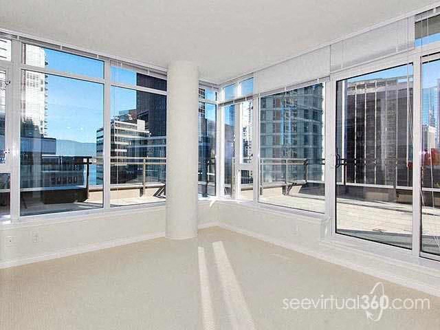A sunny day in a spacious room with large windows overlooking a cityscape.