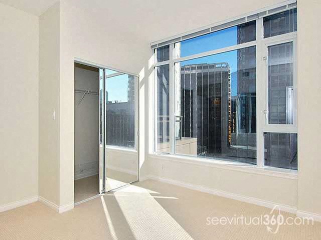 A room with a white wall and a glass door leading to a balcony.