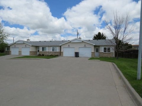 a white house with two garage doors and a driveway