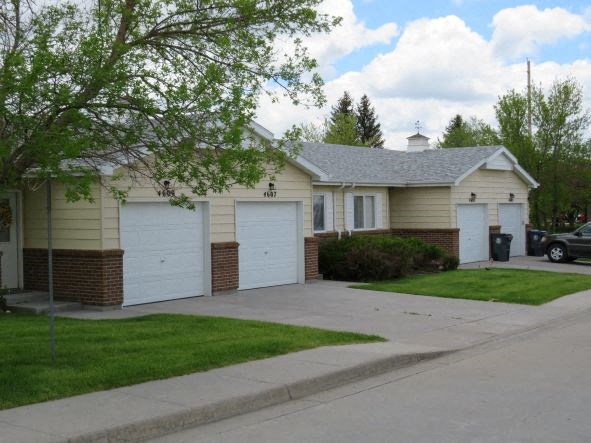 a white house with two garages and a driveway