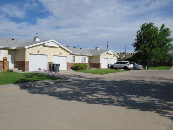 a street of houses with cars parked in the driveway