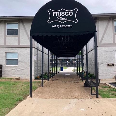 a covered walkway in front of a fisco place building