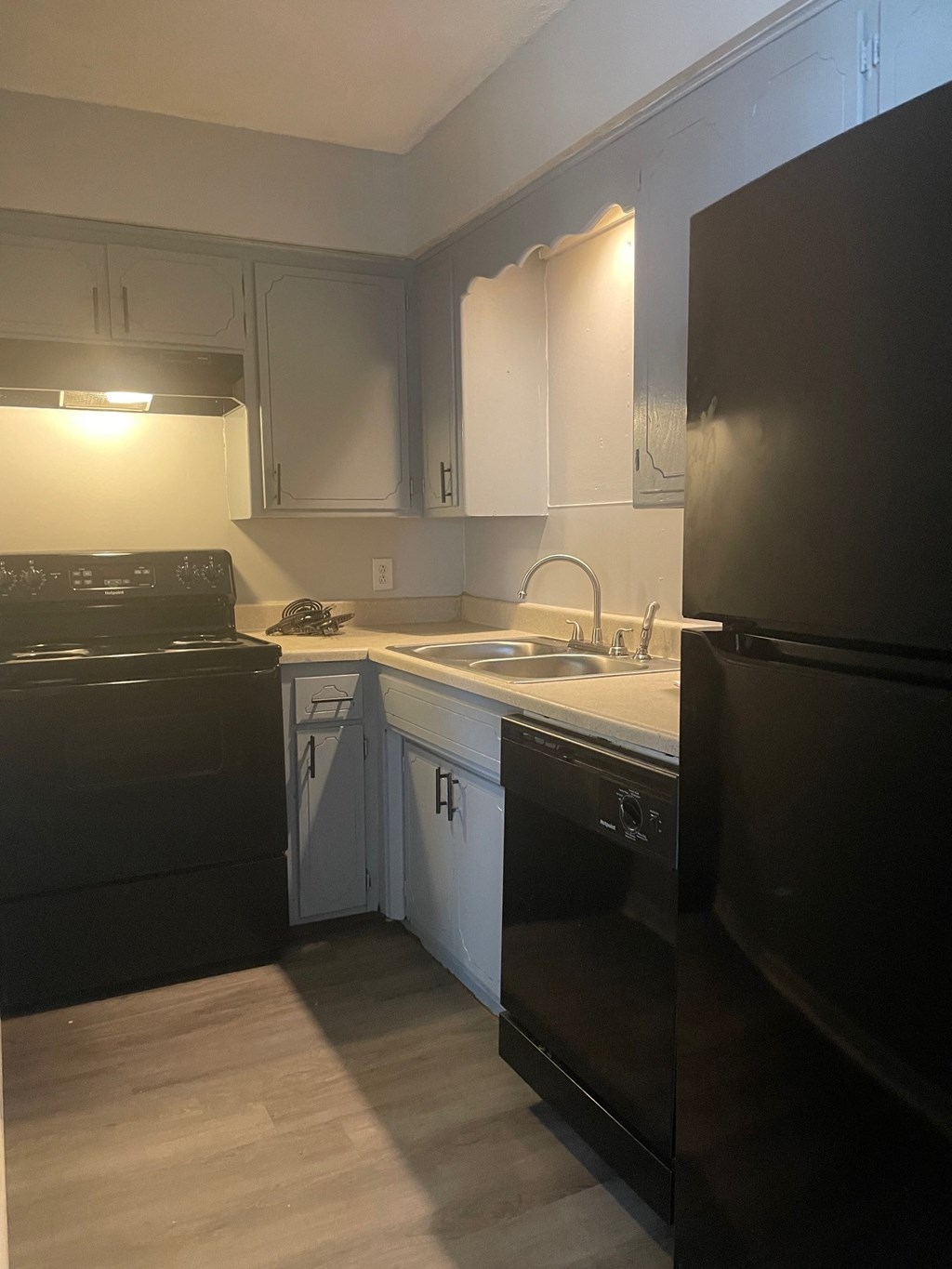 an empty kitchen with black appliances and white cabinets