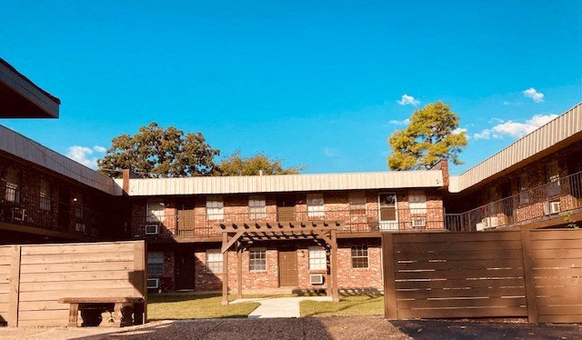 the front of a brick building with a wooden fence