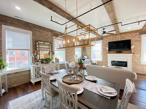 a dining room and living room with a table and chairs and a fireplace
