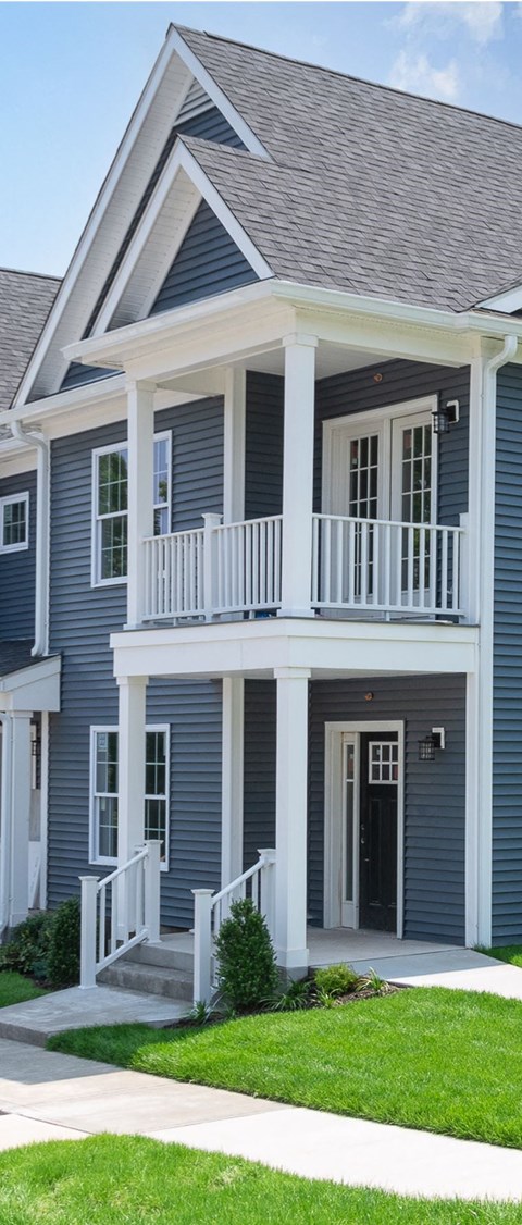 a blue house with a porch and a balcony