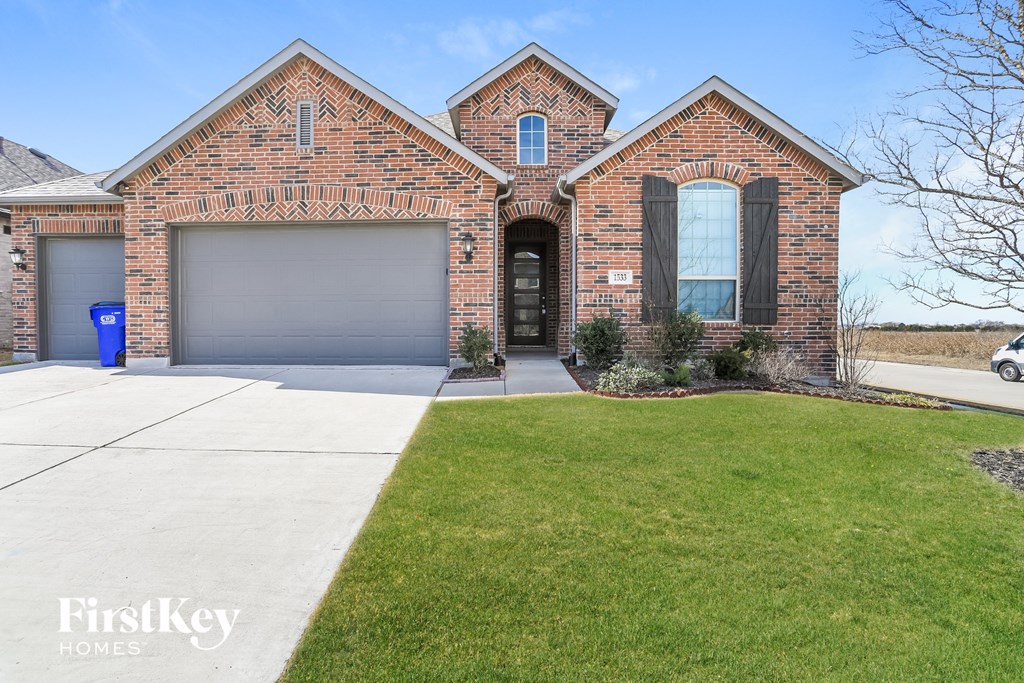a large brick house with a driveway and a garage door
