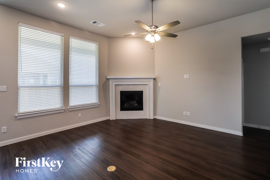 a living room with a fireplace and a ceiling fan