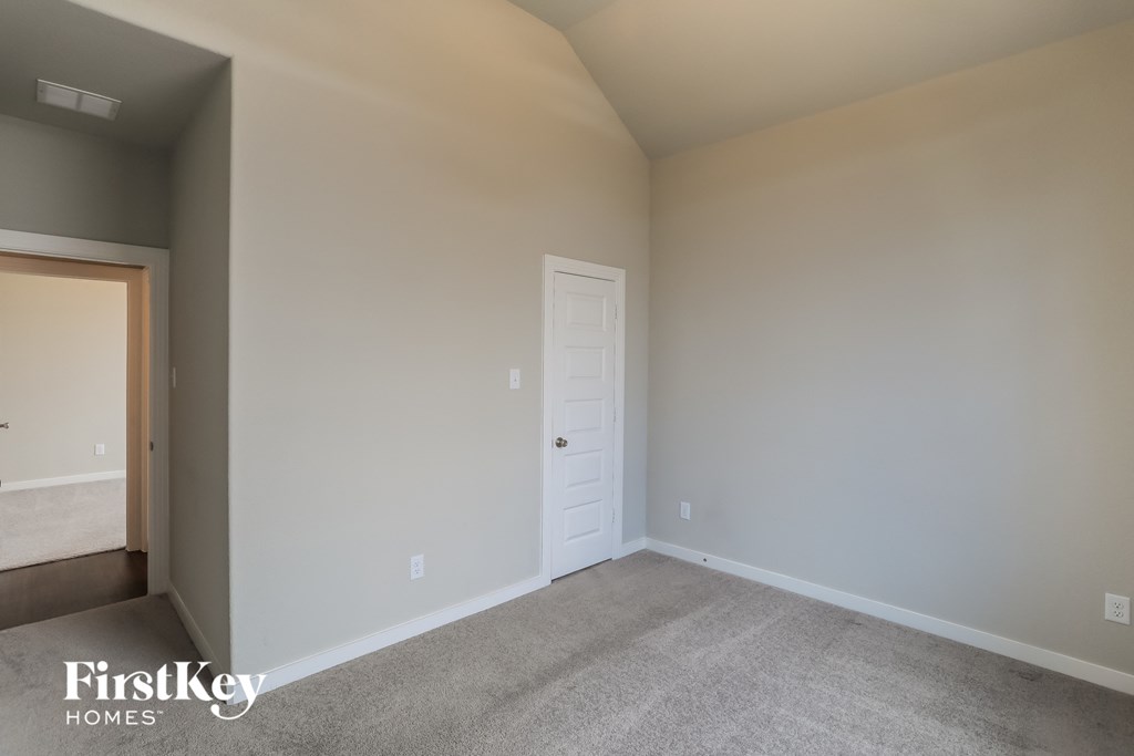 a bedroom with a white door and a carpeted floor