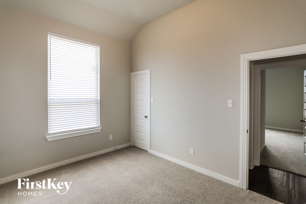 a bedroom with a door to a closet and a window