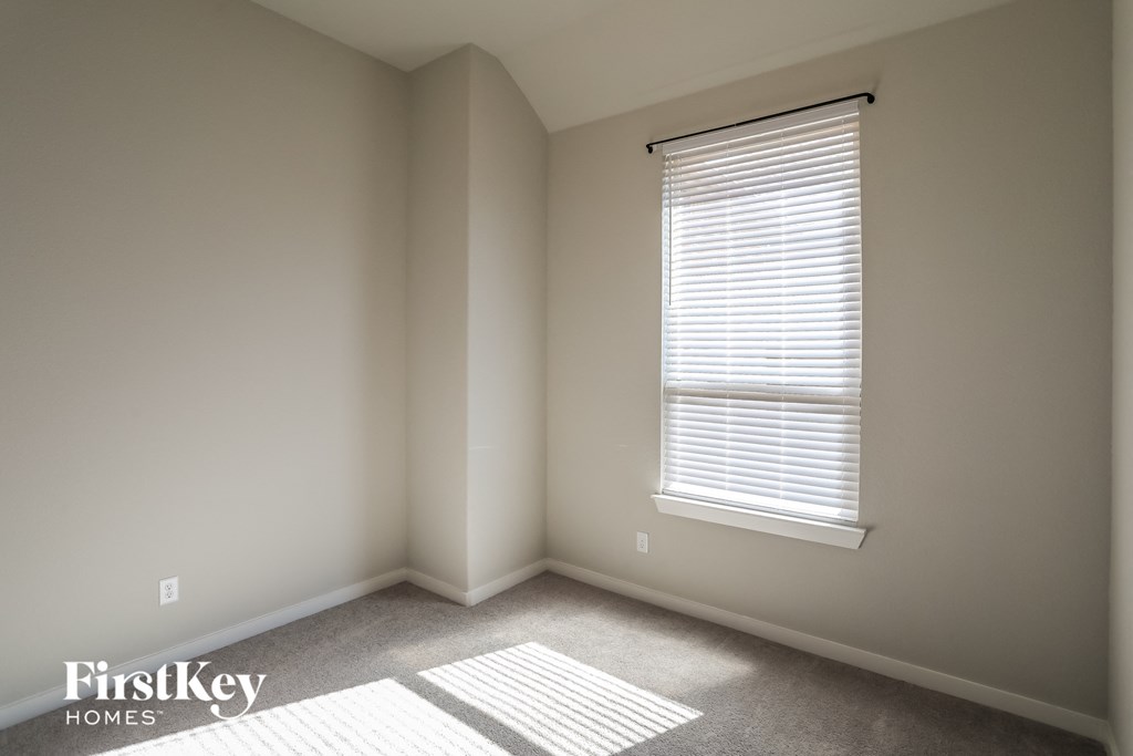 a small room with a window and a carpet