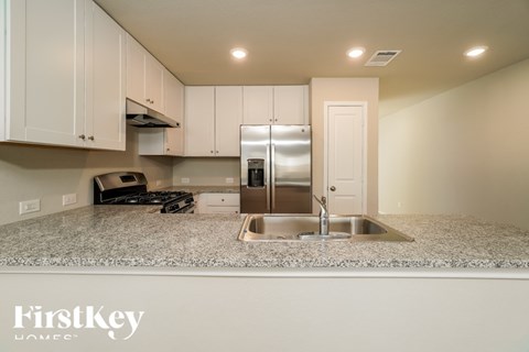 A kitchen with granite countertops and stainless steel appliances.