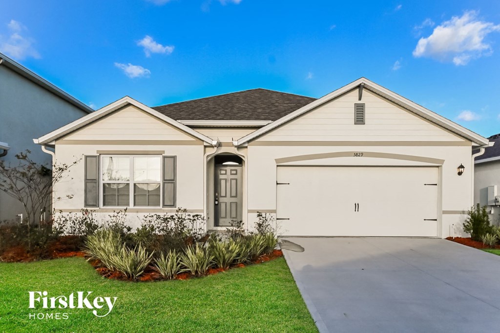 the exterior of a home with a white house and a driveway