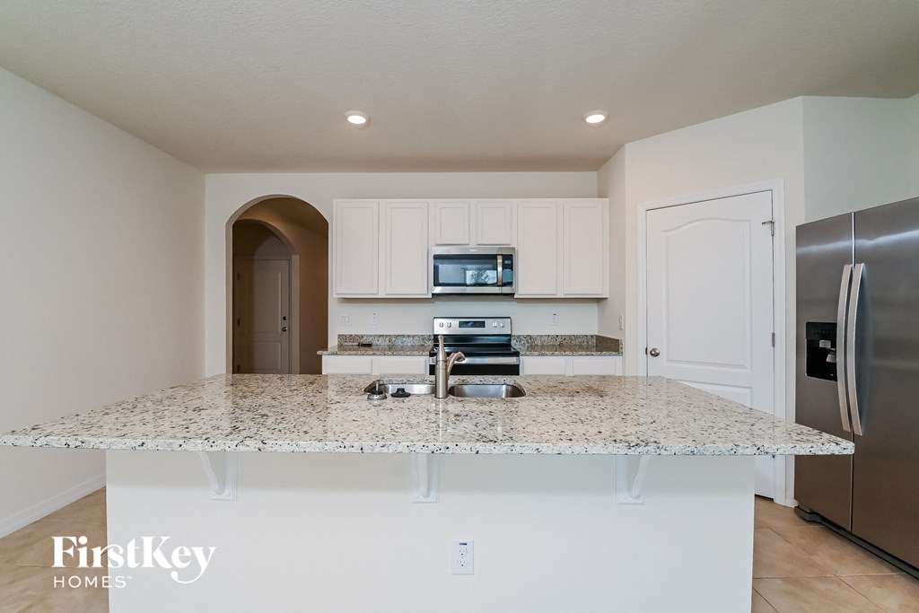 a kitchen with white cabinets and a granite counter top