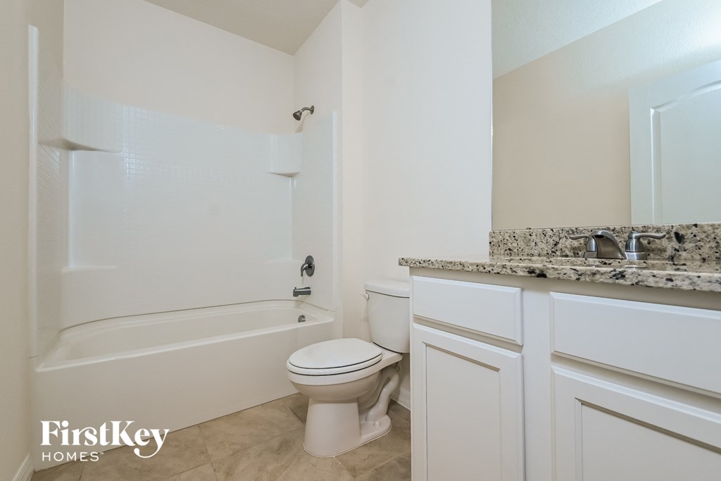 a bathroom with a toilet and a tub and a sink