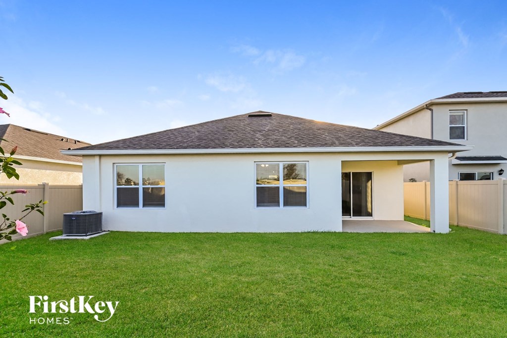 a white house with a lawn and a backyard
