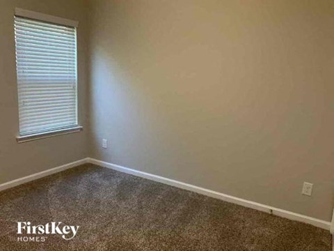 a empty room with a window and a carpet