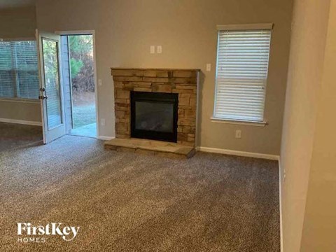a living room with a stone fireplace and a door