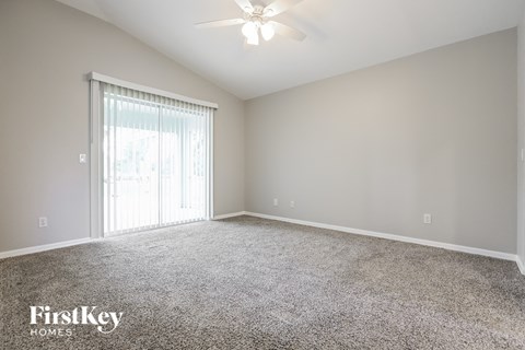 a spacious living room with carpet and a large window