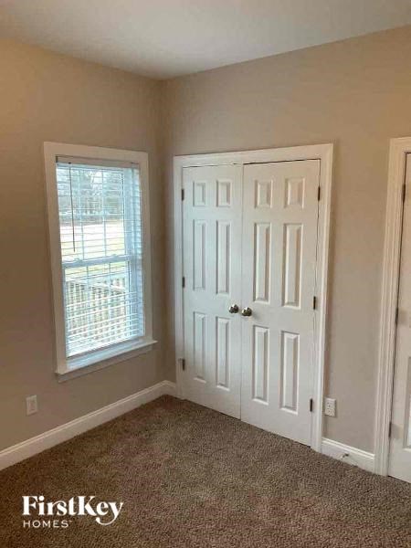 an empty room with a white door and a window