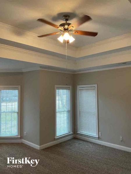 a living room with a ceiling fan and two windows