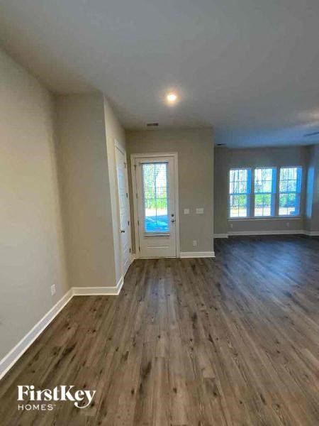 an empty living room with wood floors and a door
