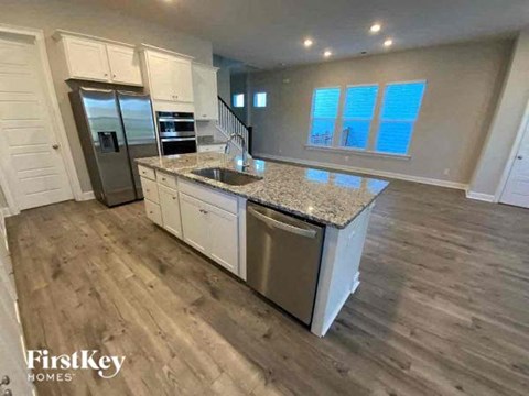 a kitchen with a sink and a stainless steel refrigerator