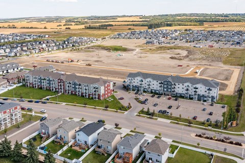 A large parking lot is surrounded by apartment buildings.