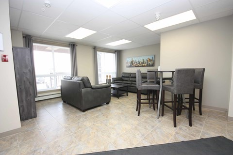 A room with a couch, chairs, and a table.