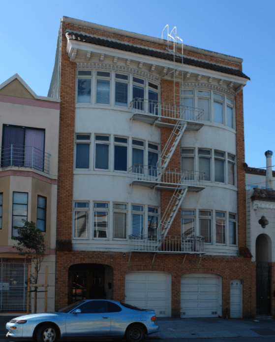 a white car is parked in front of a building