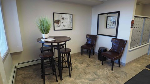 A room with a table, chairs and a potted plant.