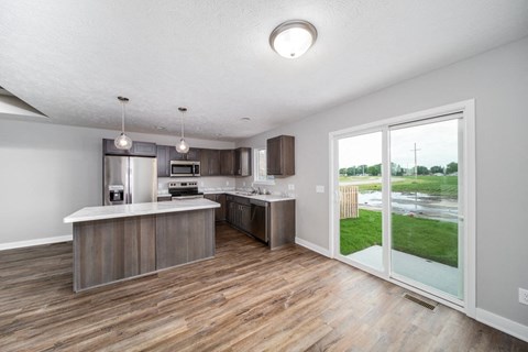 A kitchen with a wooden floor and a white ceiling.