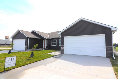 A house with a garage and a sign that says AH.