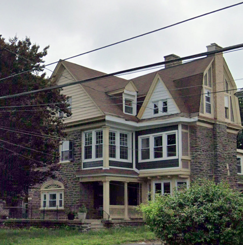 a large brick house with a gray roof and white windows