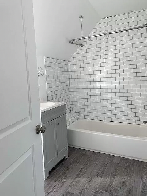 a white bathroom with a tub and a sink