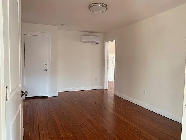 an empty room with a wooden floor and a door